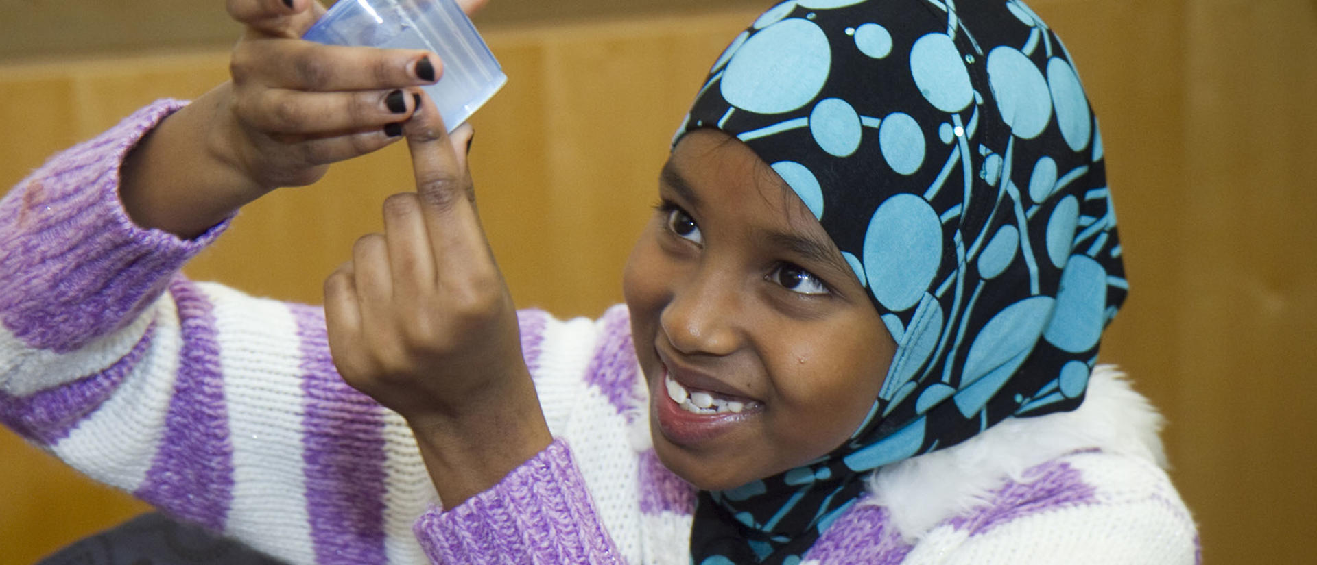 young student looking at science beaker