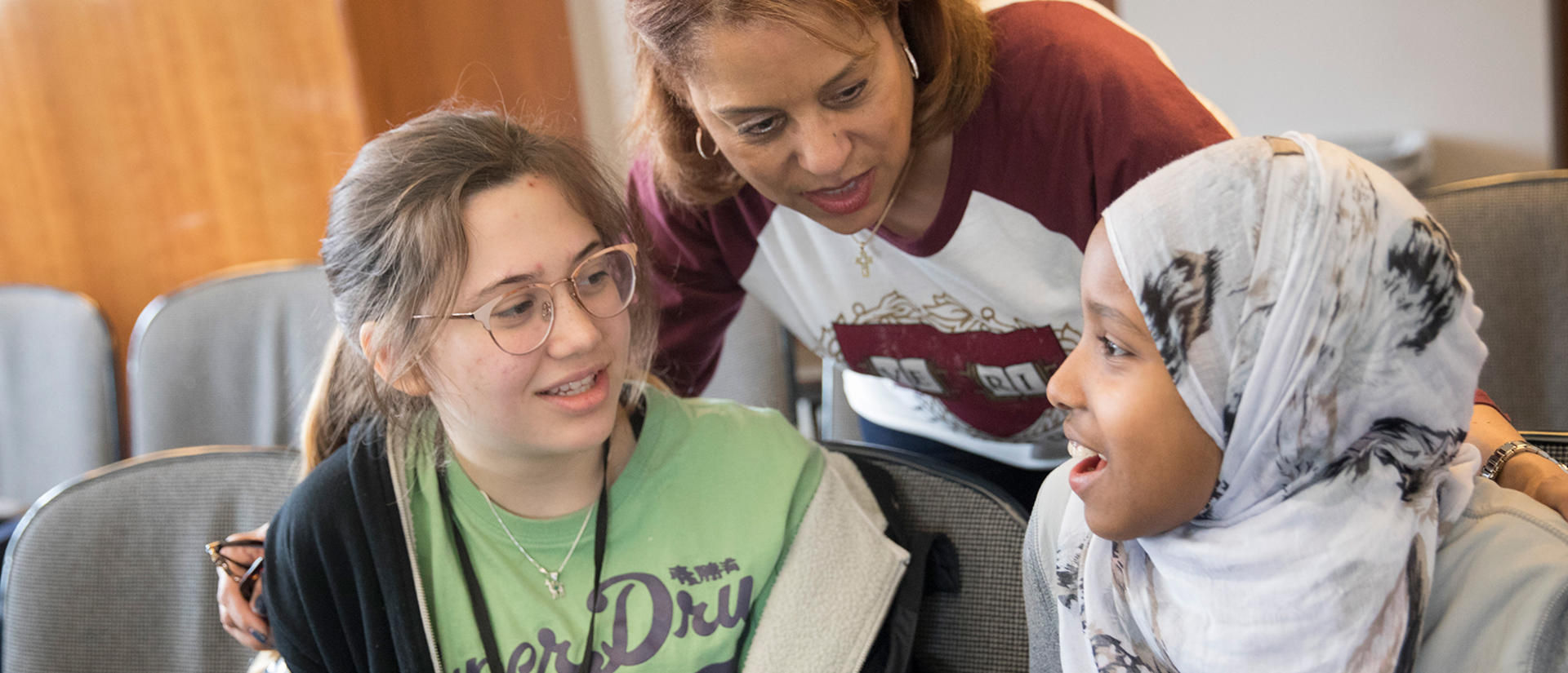 teacher talking to two seated students